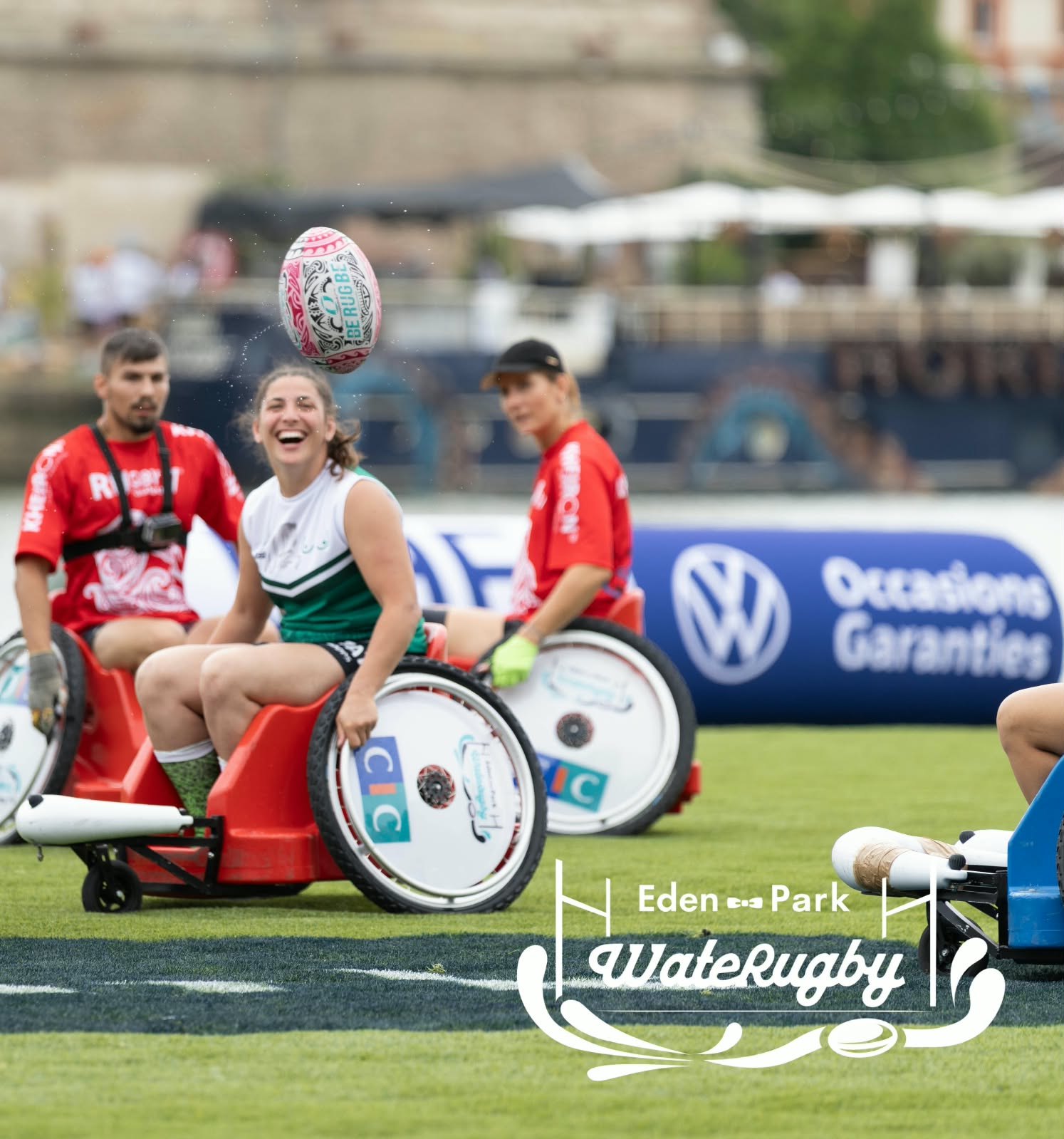 Des joueurs en fauteuil sportif participent à une rencontre sur un terrain, avec un ballon en l’air.